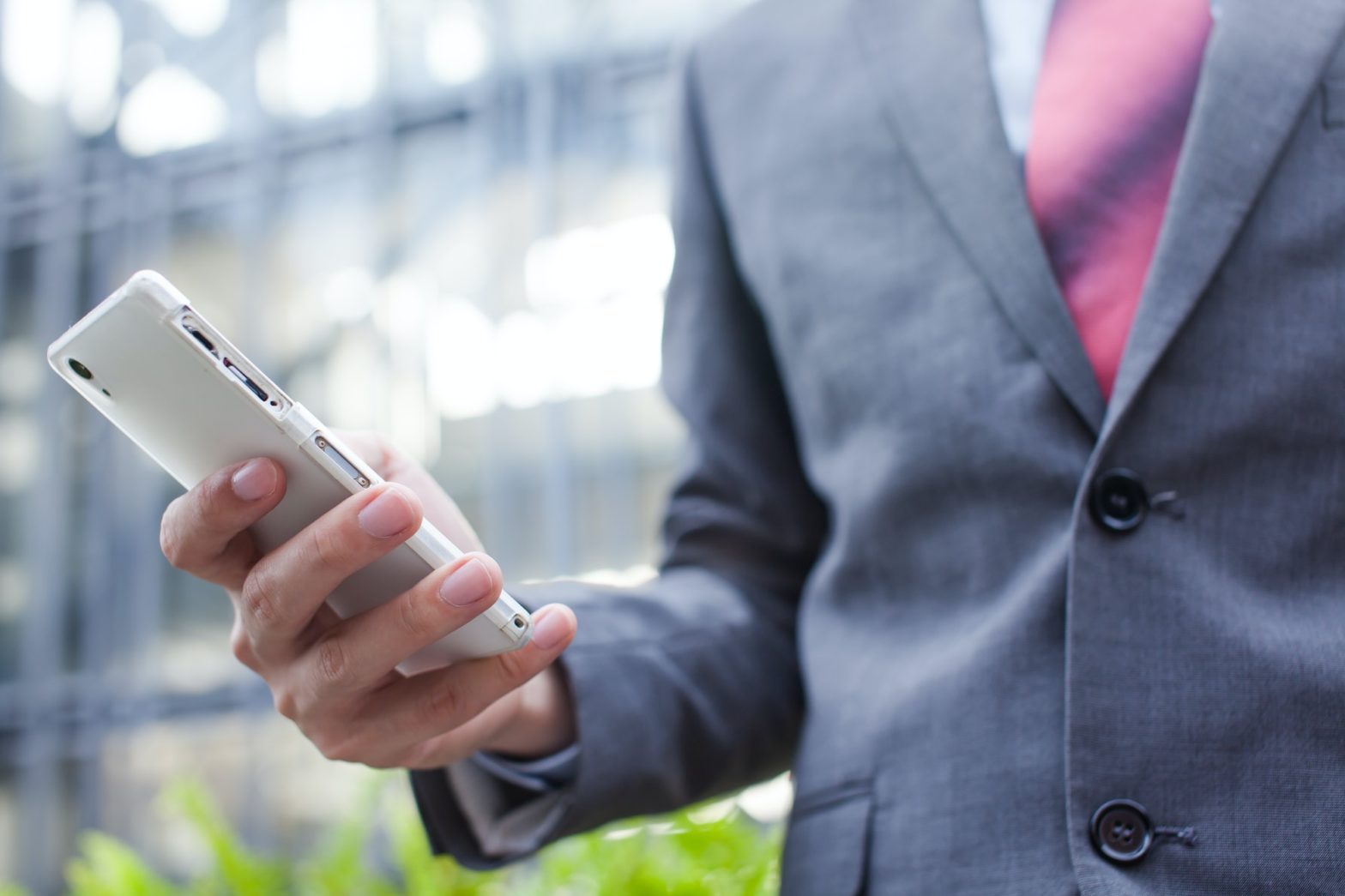 Business man using a cellphone (focus on cellphone)