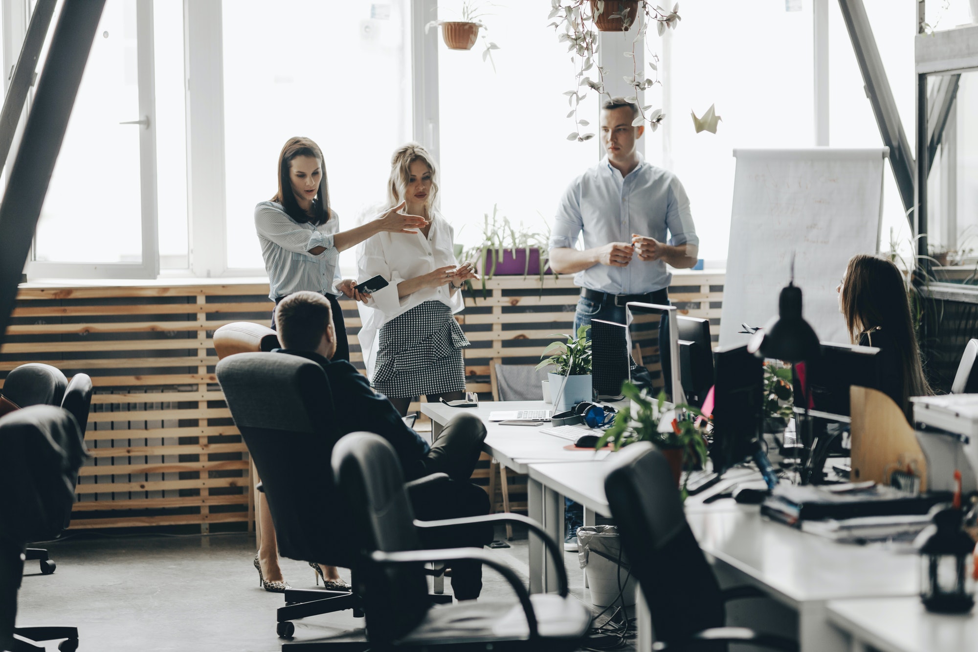 Staff meeting of a young successful team in the light modern office equipped with modern office