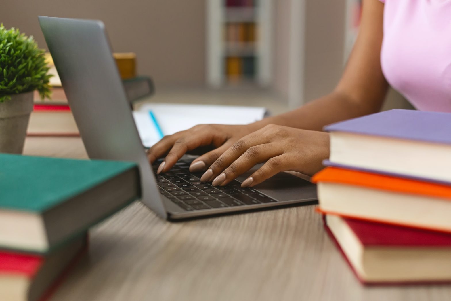 Afro girl using laptop and books for education